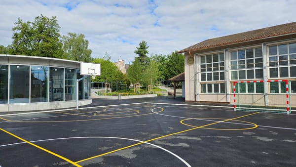 Die Doppelturnhalle liegt unter dem Hartplatz und ist über den runden Glasbau links im Bild zugänglich.