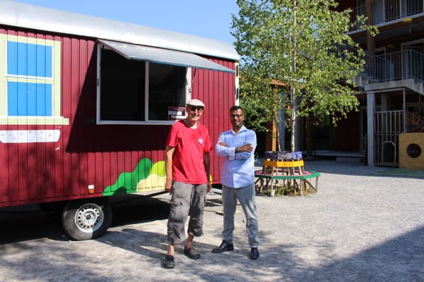 Scander Mohamed (rechts) und vor dem Quartier-Mobil, das im Durchgangszentrum Sihlau für zwei Wochen seine Türen öffnet.
